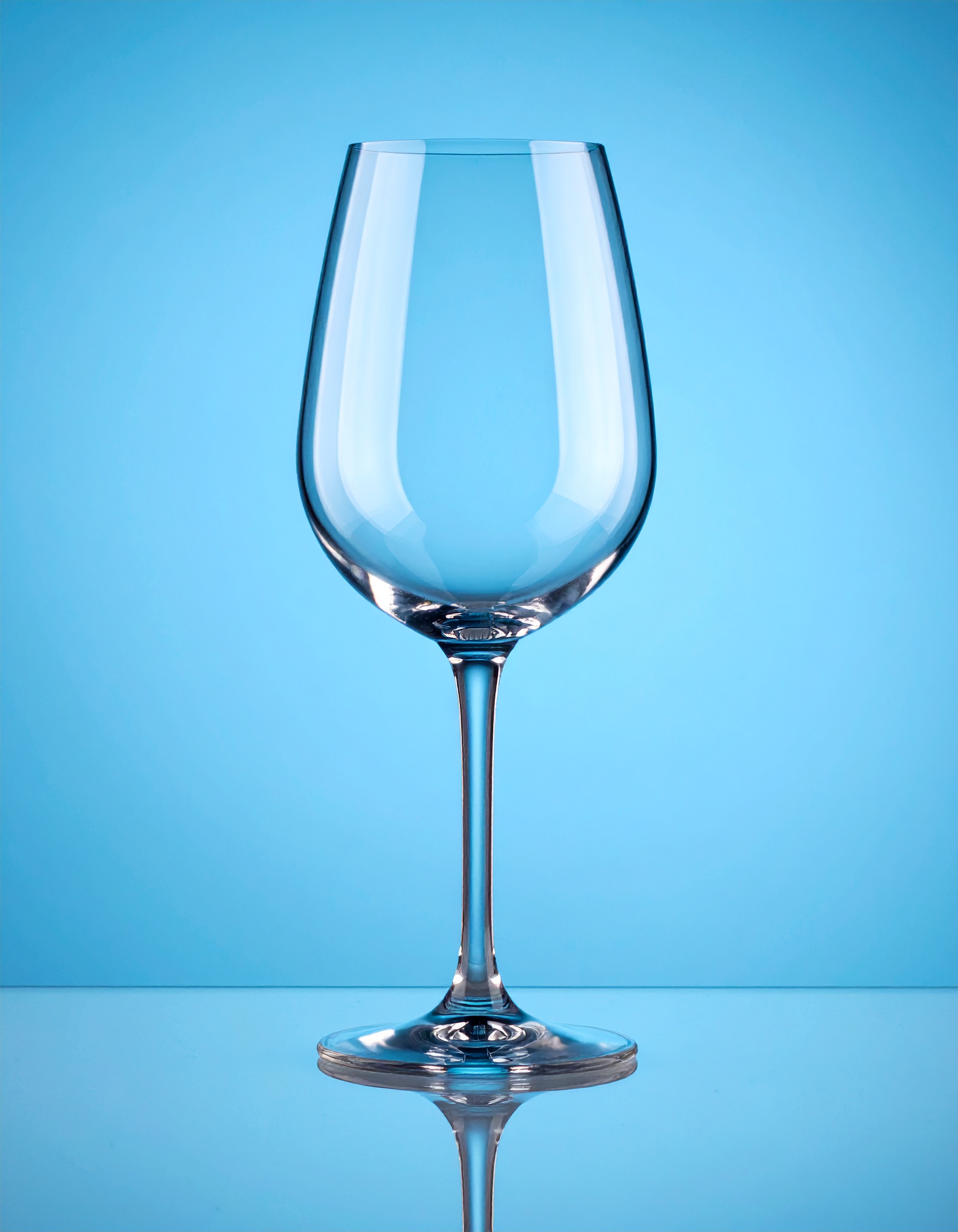 Firefly_empty wine glass; blue studio background 111156